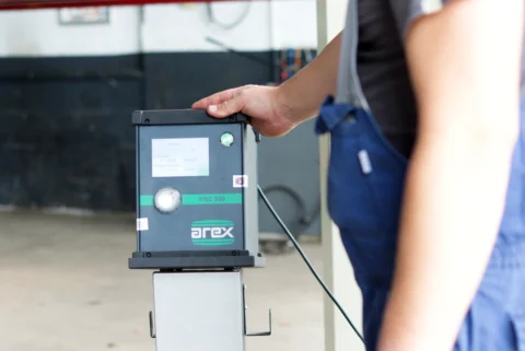 Een automonteur doet een roetmeting tijdens een APK keuring in de garage